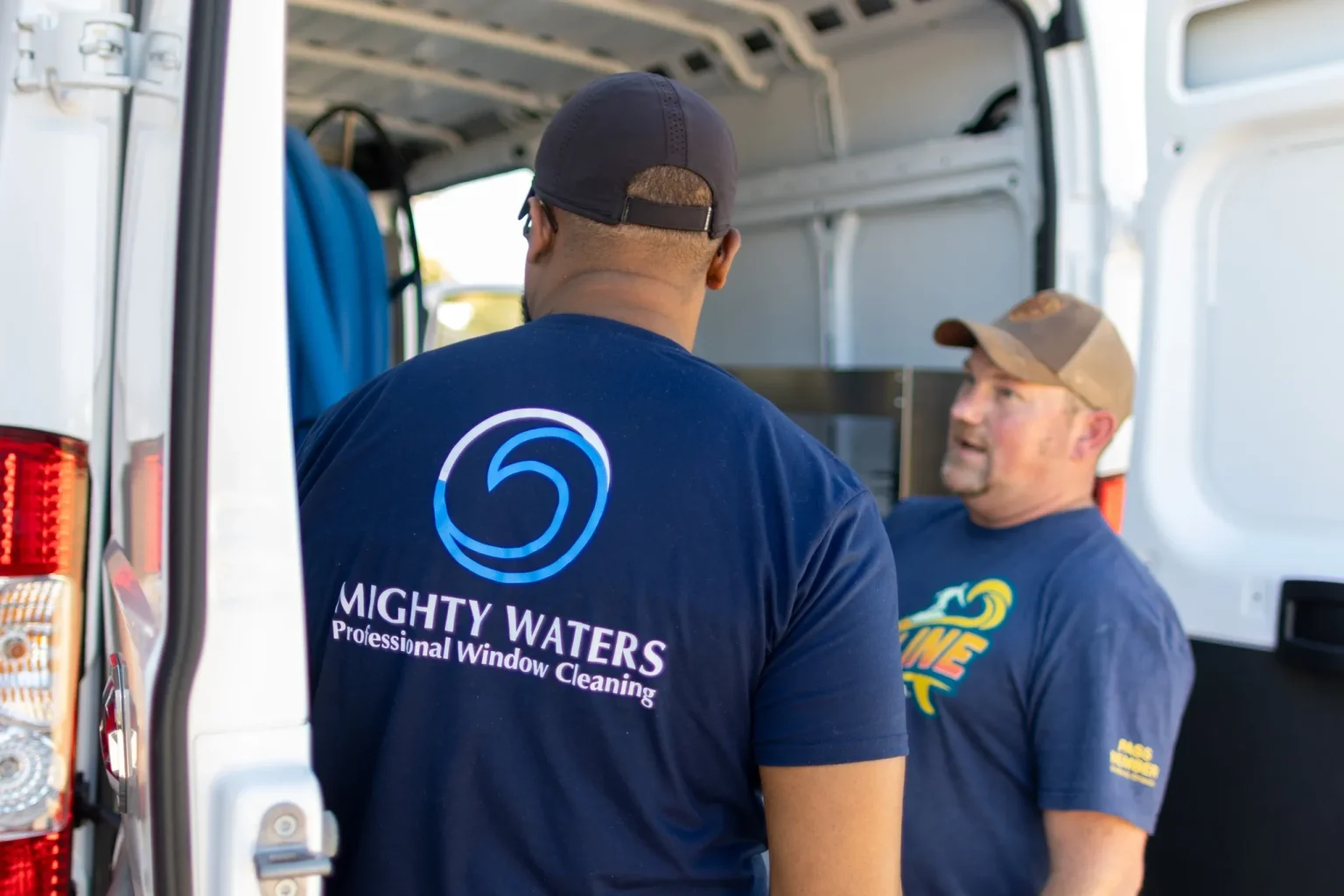 Mighty Waters crew in branded shirts at their service van